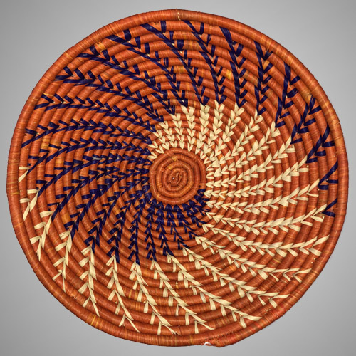 A vibrant orange handwoven basket made by a Ugandan artisan.